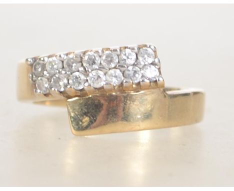 A 9ct gold hallmarked Birmingham dress ring set with clear pave set stones in an overlapping twin band Maker WJJ. Weight 3.4g