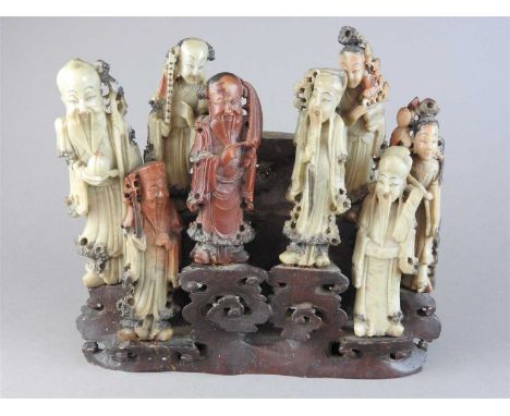 A Chinese carved soapstone group of the eight immortals, each figure modelled separately in red and light green tones and rai