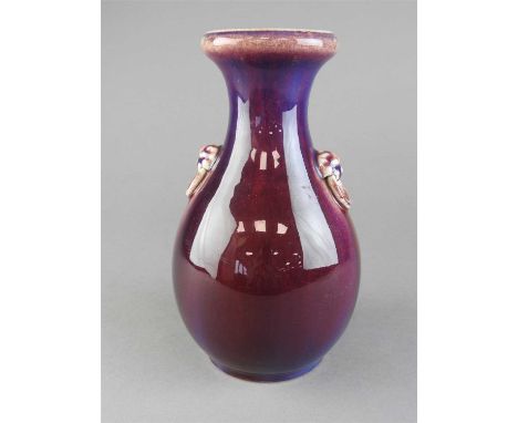 A Chinese flambe pear shaped vase, Qing Dynasty, 19 th century with lion mask ring handles and streaked with violet lavender 