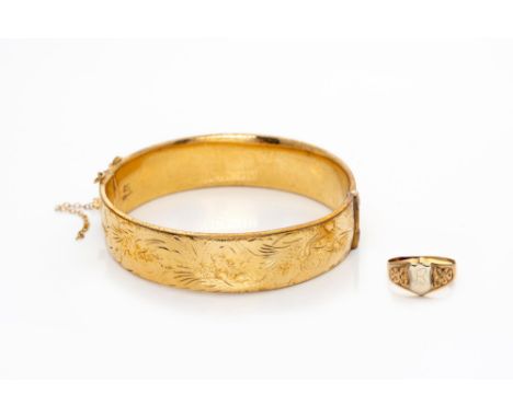 Oval, designed as a broad band, the top half chased with scrolling foliage, inner width approximately 6cm; and An 18ct Gold C