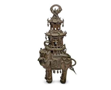 Modelled and cast as an elephant dressed in ceremonial dress, it's trunk held upright, cast in high relief with dragons and a