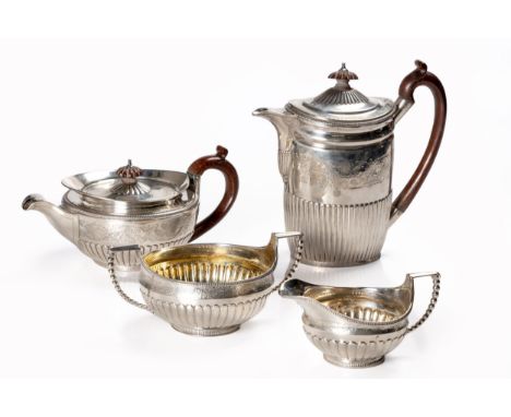 Each hinged cover with chased key lock pattern and wooden finial, gadrooned rim, leaf-capped handle, the body chased with aco
