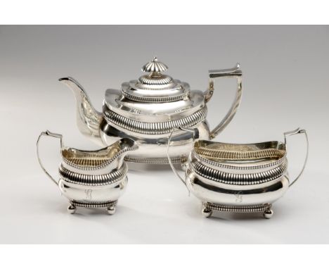 Comprising: a teapot, milk jug and sugar basin, the teapot with hinged cover, gadrooned finial, each with oval bodies, gadroo