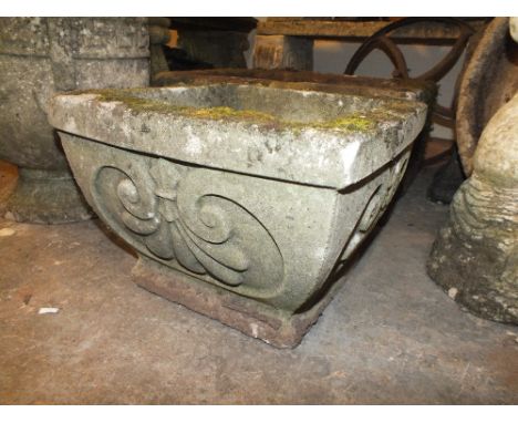 A SMALL SQUARE STONE PLANTER
