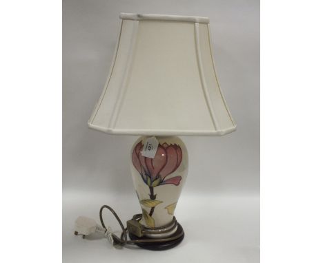 A MOORCROFT MAGNOLIA PATTERN TABLE LAMP, cream ground with typical tubelined decoration, raised on a circular wooden plinth, 