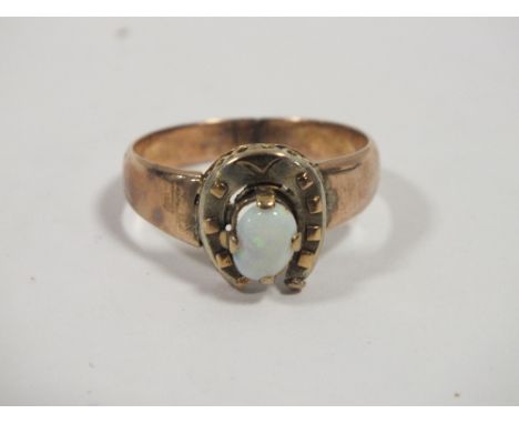 A LADIES EQUESTRIAN INTEREST HORSE SHOE AND OPAL RING 