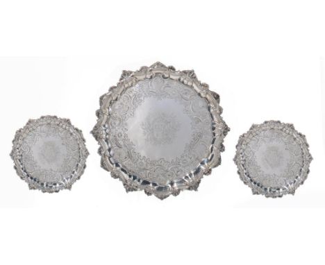 A SET OF THREE GEORGE II ROCOCO SILVER SALVERS the field engraved with armorials in flat chased border, on three paw feet, 18