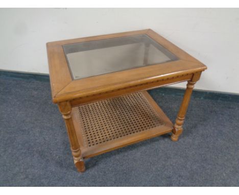 An American style glass topped coffee table with bergere under shelf 