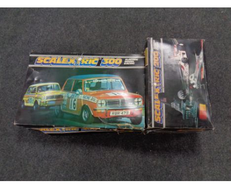 A boxed Scalextric 300 electric model racing set complete with cars, together with a Scalextric 200 box containing track only