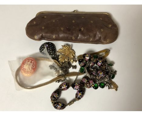 A vintage lady's purse containing a small quantity of costume jewellery, cameo brooch etc 