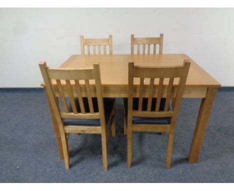 A contemporary extending dining table fitted a leaf together with a set of four ladder back chairs in an oak finish 