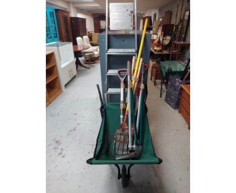 A folding barrow containing garden tools together with an aluminium stepladder 