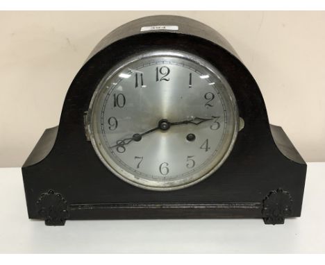 An early twentieth century oak cased mantle clock with pendulum