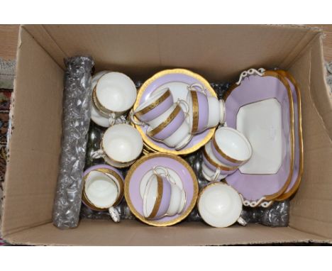 A Cauldon tea set, each piece decorated with a lilac and white body with gilt rim, comprising 12 cups, 12 saucers, 12 plates,