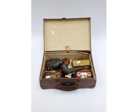 A Victorian small leather suitcase containing: a pair of 19th Century leather and steel cock fighting spurs, a Rabone measure