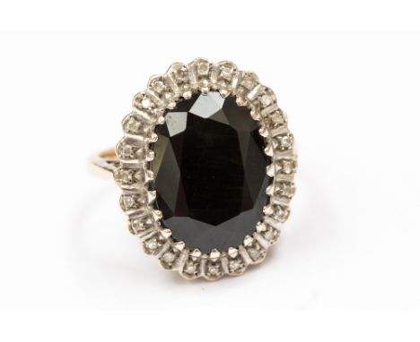 A 9ct gold blue sapphire and diamond cluster ring, set with an oval sapphire approx 14mm x 10mm with a diamond surround, size