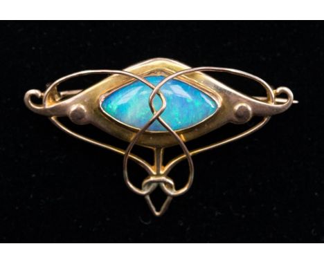 An Arts and Crafts 9ct gold and opal brooch, with sinuous wirework over a central lozenge shaped cabochon crystal opal, by ma