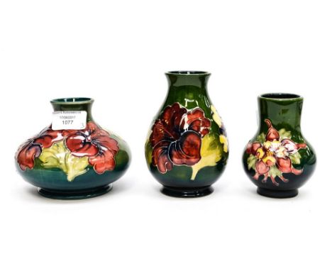 A squat Moorcroft vase, with two further Moorcroft vases, all on green ground (3)