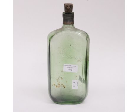 A 19th century glass bottle with moulded armored arm holding an axe