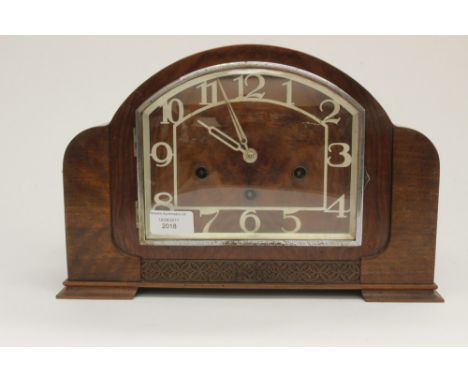 A 1930s Art Deco Walnut veneered , eight day mantle clock, having a Westminster chime, the case with blind fretwork decoratio