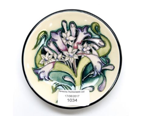 A small Moorcroft circular pin dish, tube line decoration on a cream ground