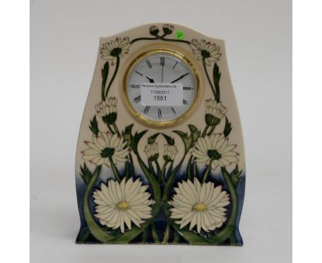 A Moorcroft clock in the Daisy May pattern. 1st quality, in unusual colourway, having cream flowers on cobalt ground, fading 