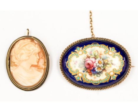 An Edwardian yellow metal and enamel brooch, the decoration on a porcelain body, initials and decoration in gilt and enamel, 