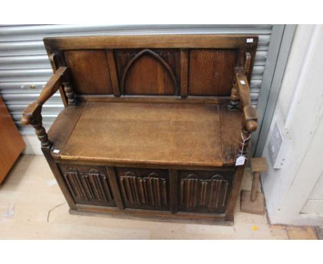 An early 20th Century oak Monks bench, the front with linenfold panels 