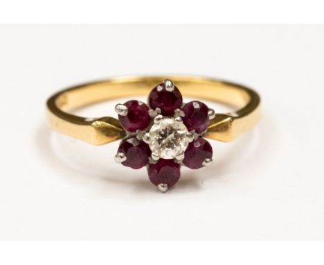 A ruby and diamond flower cluster ring, claw set central brilliant cut diamond of approx 0.2 ct and six surrounding rubies, s