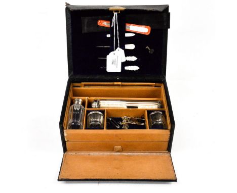 A ladies leather travelling vanity case, with faceted glass pots, and original brush, comb, nail set etc, (no handle) dated 1