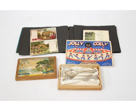 A vintage box with EPNS utensils/cutlery, an album of cards (post and birthday) and a Golliwog illusion set 