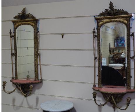 A pair of ornate Victorian gilt gesso-framed pier glass mirrors, with fern leaf pediments, display shelves below and candle b