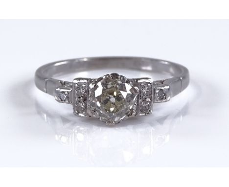 An Art Deco platinum solitaire diamond ring, with diamond set shoulders, total diamond content approx 0.7ct, setting height 6