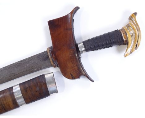 A large Malayan Kris dagger, with carved elephant's tooth hilt, original silver banded hardwood scabbard, overall length 70cm