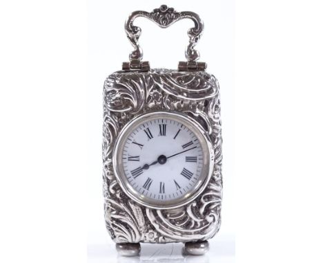 A miniature Edwardian silver-cased travelling timepiece, allover relief embossed decoration, with enamel dial and swing handl