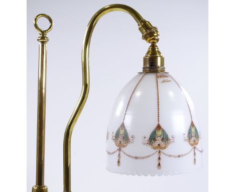 A brass rise and fall desk lamp with transfer decorated milk glass shade, height 47cm