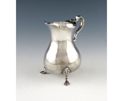 A George III Channel Islands silver cream jug, by Thomas Mauger, Jersey circa 1760, baluster form, wavy-edge border, leaf cap