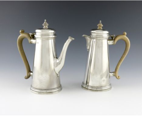 A pair of silver cafe au lait pots, by R. Comyns, London 1959 and 1960, tapering circular form, scroll handles, the domed hin