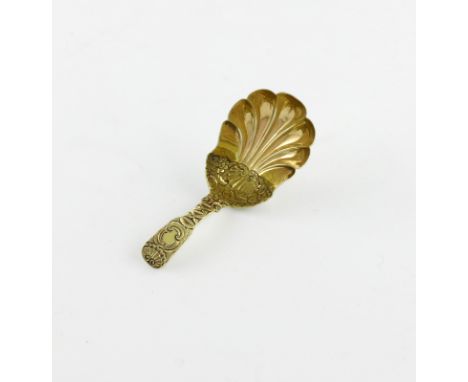 A George IV parcel-gilt silver caddy spoon, makers mark partially worn, W.H, London 1823, shell shaped bowl, with shell and f