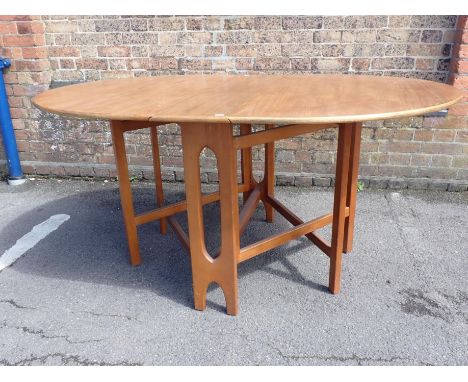 A MID-CENTURY TEAK DROP-LEAF OVAL DINING TABLE of slender profile, with overlapping double gate-leg supports 107 x 154cm (ope