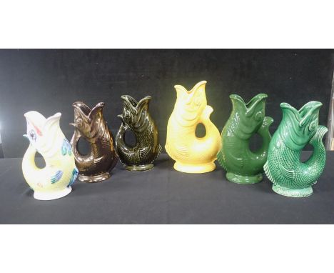A COLLECTION OF DARTMOUTH GURGLE JUGS tallest yellow 27cm high, to include 'Old Rarity Scotch', two multicoloured and a lustr