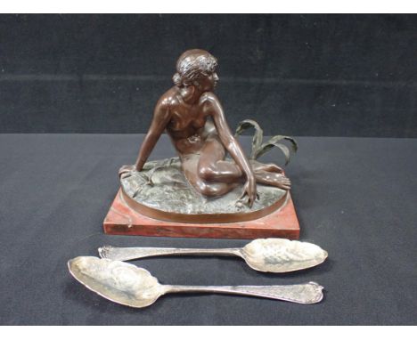 A PATINATED BRONZE FIGURE OF A WOMAN ON A RED MARBLE BASE 17cms high, together with a pair of silver plated spoons