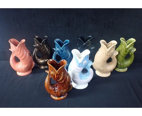 A COLLECTION OF DARTMOUTH GURGLE JUGS 23cms high, to include a brown Plymouth Gin, a bronze lustre, a multi-colour and five o