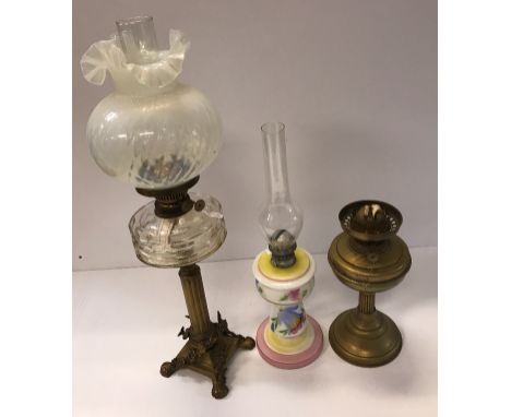 A circa 1900 brass Corinthian column oil lamp set with flowers raised on paw feet with vaseline glass shade, together with a 