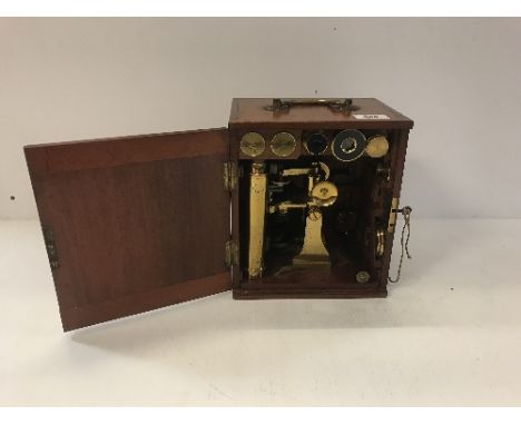 A late Victorian mahogany cased lacquered brass monocular microscope by Dolland of London with various lenses and accessories
