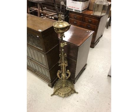 A brass telescopic oil lamp standard in the Art Nouveau taste, the reservoir on central pillar and sinuous tripod supports, u
