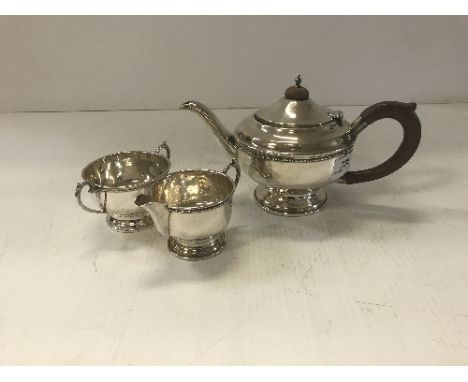 A George V silver tea set with beaded decoration raised on a circular foot (Birmingham 1933 by James Walter Tiptaft - teapot 