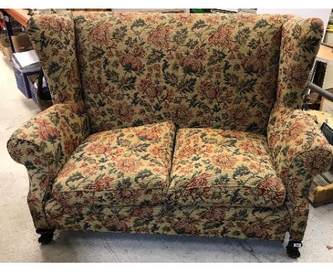 An early 20th Century upholstered wing back scroll arm two seat sofa on squat cabriole legs to claw and ball feet, 162 cm wid