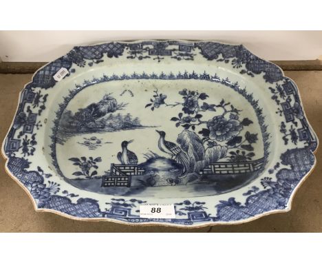 An 18th Century Chinese blue and white porcelain serving platter with shaped rim enclosing a centre field decorated with two 