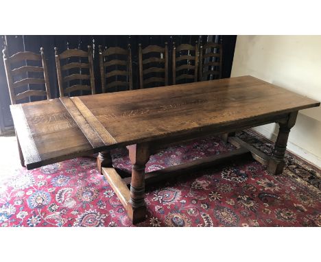 A modern oak refectory style dining table in the 18th Century manner, the plank top with cleated ends on turned legs to block